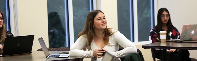 student in classroom looking excitedly towards teacher