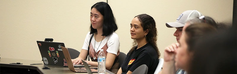 smiling students in classroom listening to lecture