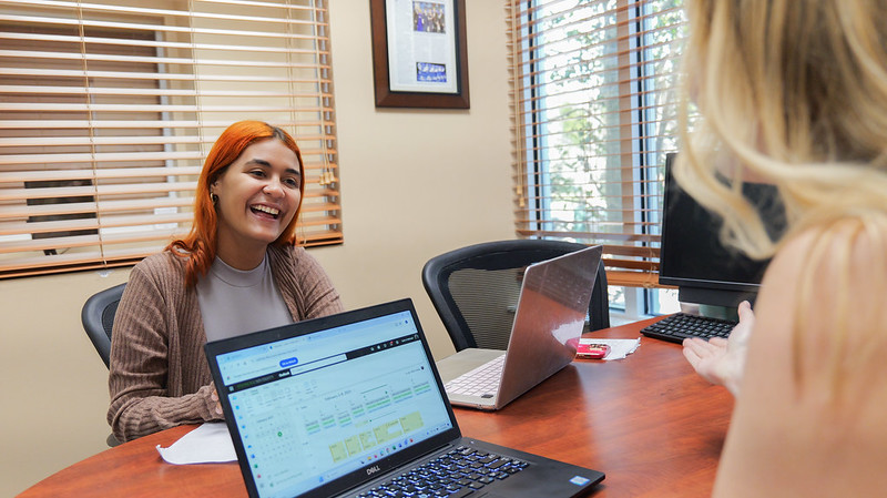 student and professor in lab using laptops
