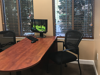 desk with computer and two chairs