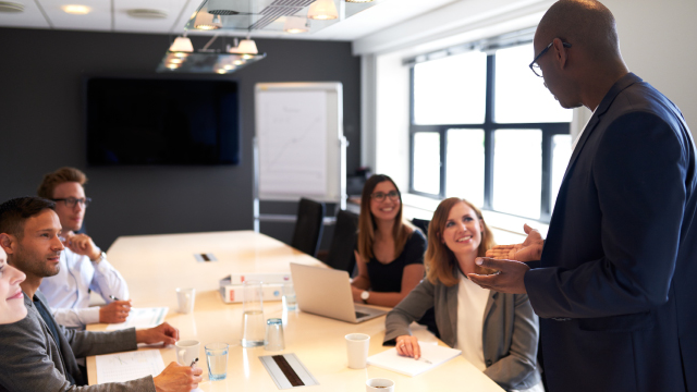 man presenting to colleagues in board room