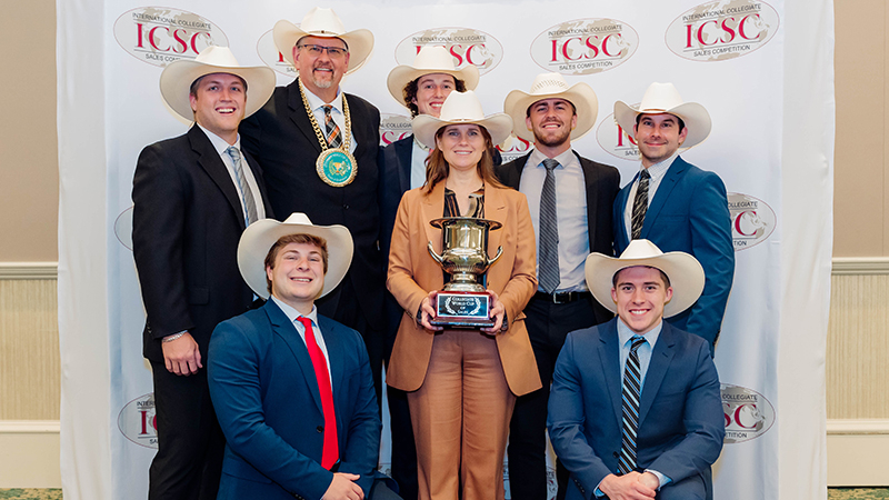 students posing for group picture after winning competition