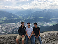 three students on top of a mountain