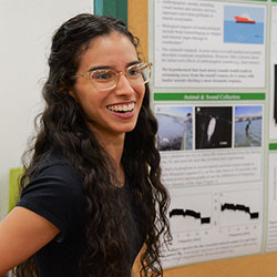 student presenting their research poster