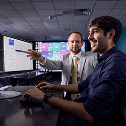professor teaching a student at a classroom computer