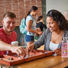 Students at a table in a busy university space, engaged in an academic activity.