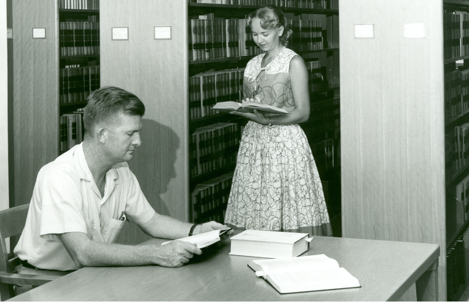 A male and a female student in the Law Library in the 1950s