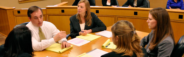 Group of students with professor reviewing notes