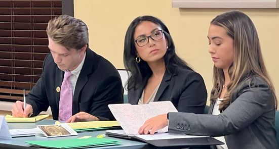 three students working together in a classroom