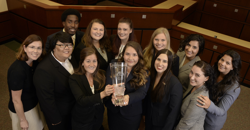 Advocacy students stand with trophy
