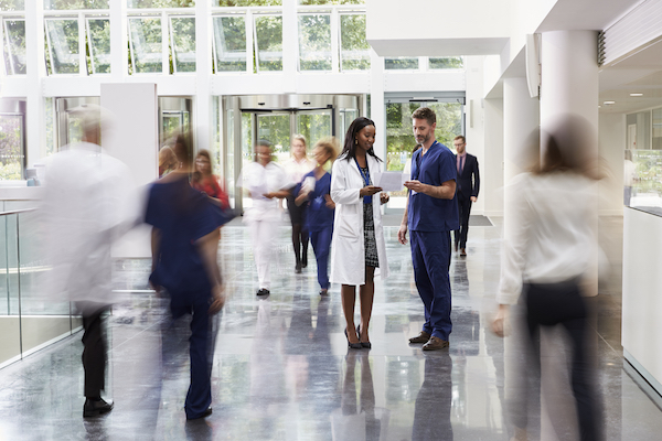 Doctor and nurse chat in a busy hospital