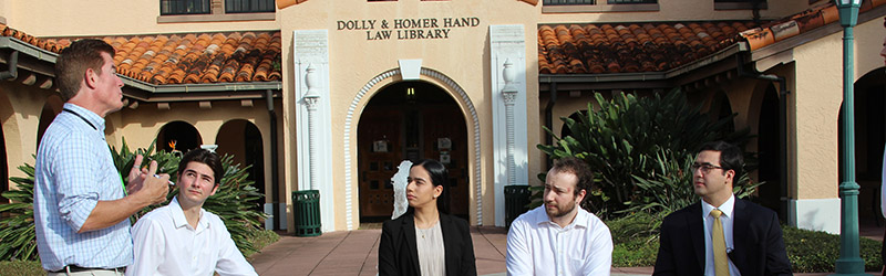 students talking outside of dolly homer hand library with professor