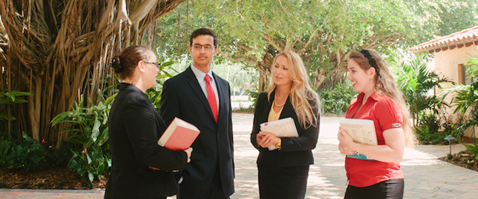 a group of students in a meeting in the banyan courtyard