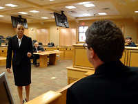 Law student questions witness within on-campus courtroom.