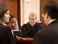 Professor listens to student jurors inside courtroom.