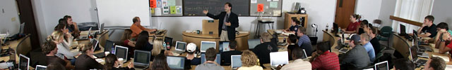 Professor speaks to students in large classroom.