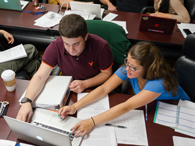 two students going over notes on computer