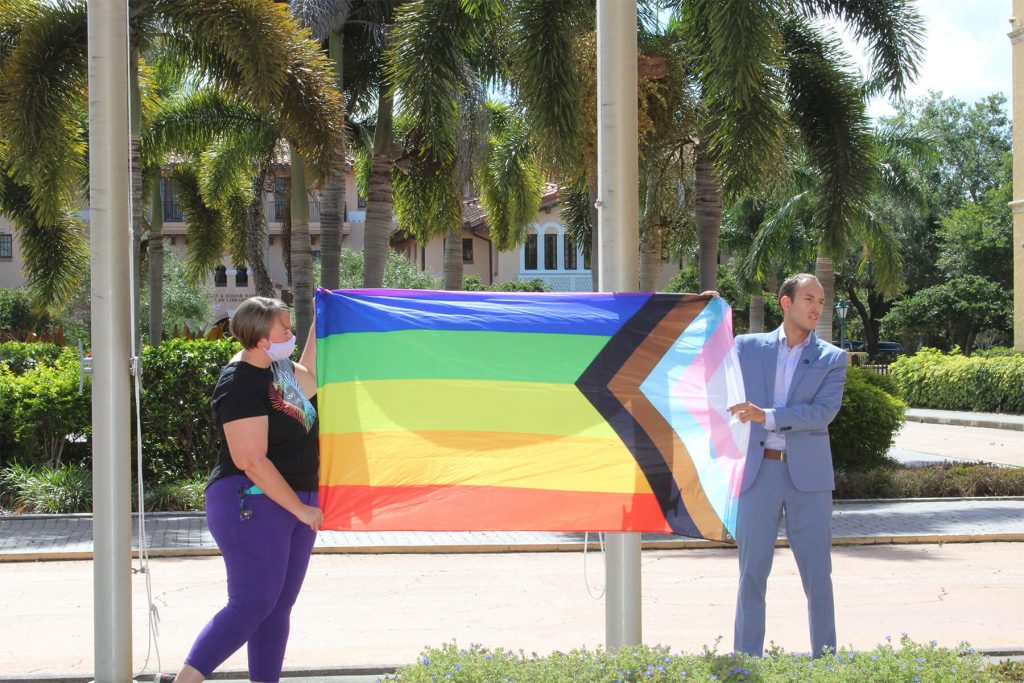 Jen Rex, left, and Edson Abadia Jr. with the Progress Pride Flag.