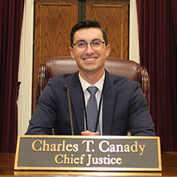 Adam Poe at Justice Canaday's seat on the bench.