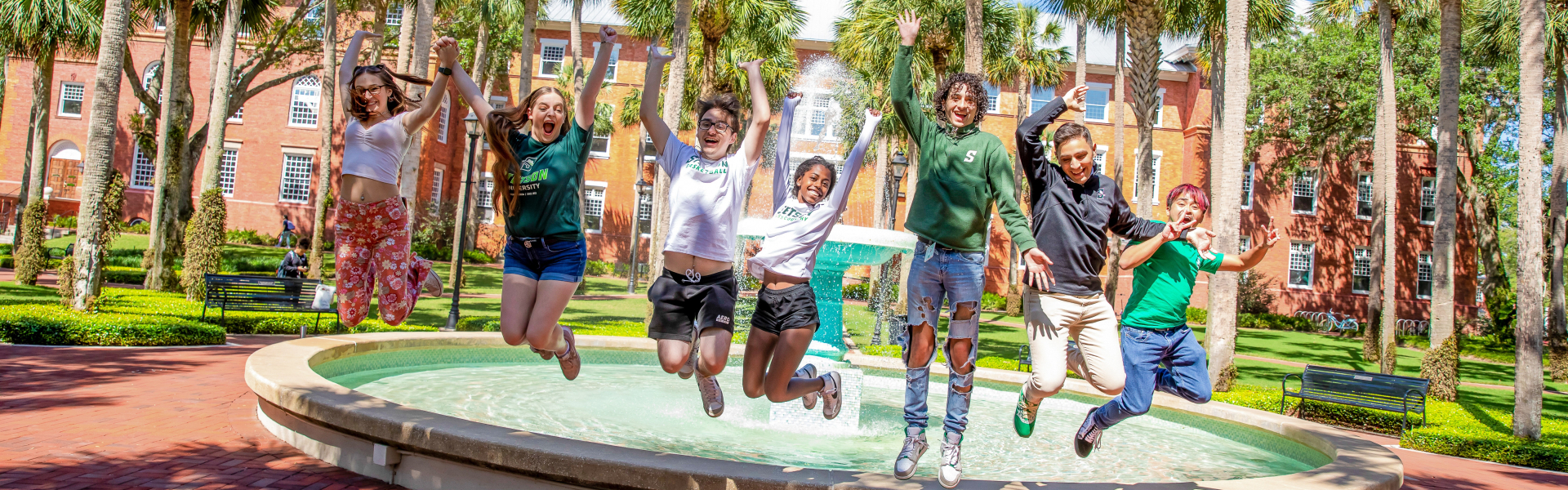group of students jumping in front of the holler fountain