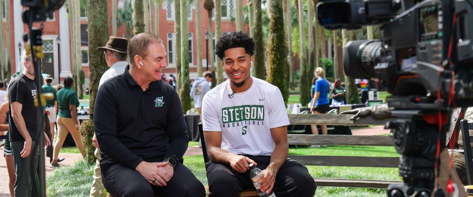student and coach getting interviewed outside on campus