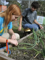 Two students serving at a community garden 