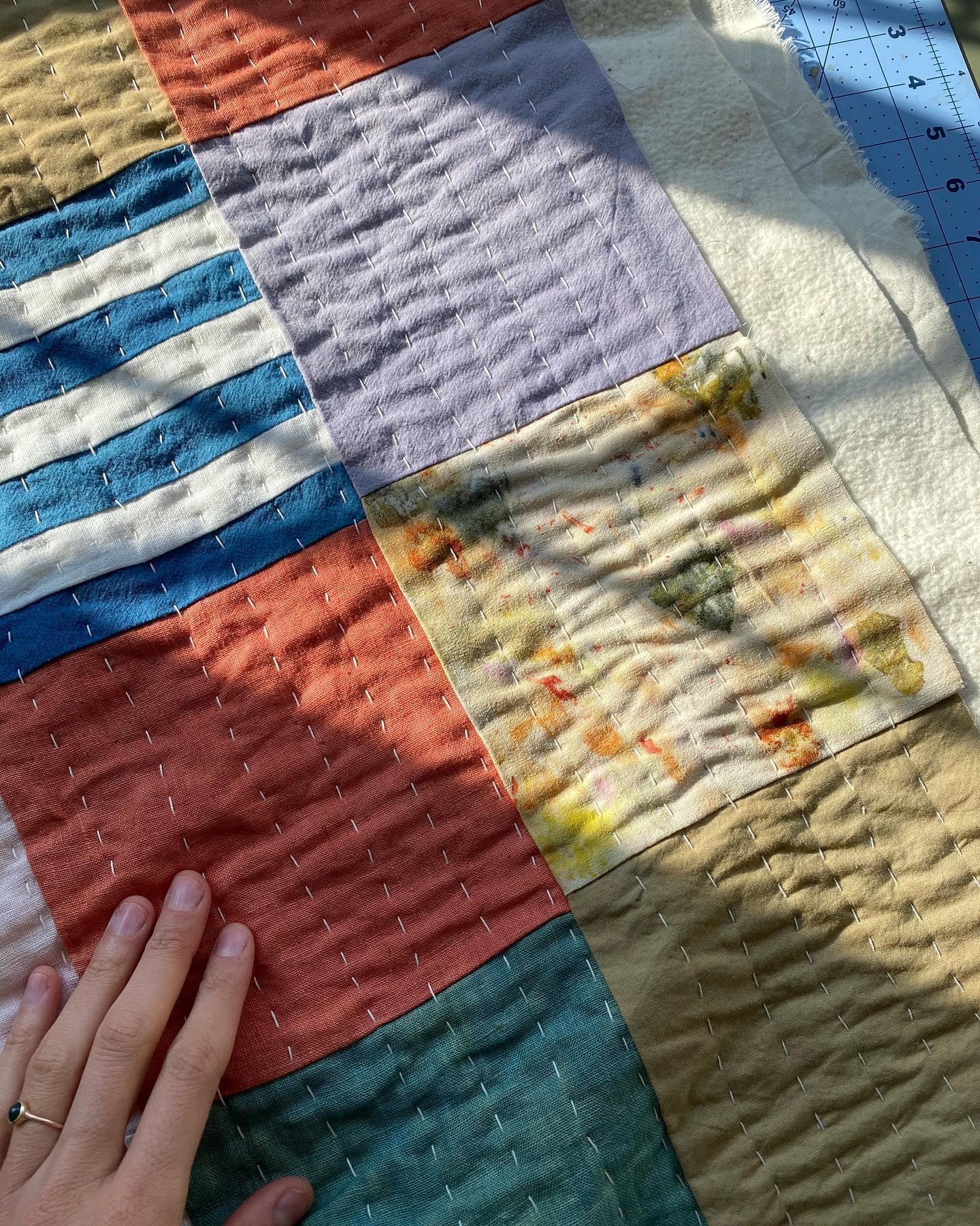 A quilted piece with a patchwork design comprising multiple color blocks