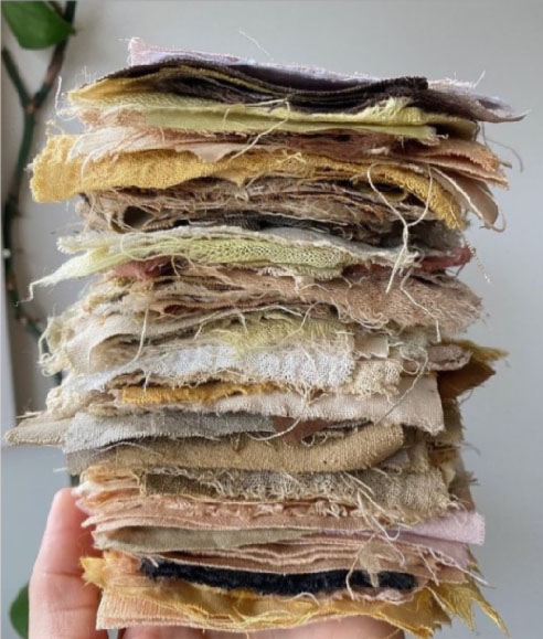 A stack of fabric squares in a variety of tones