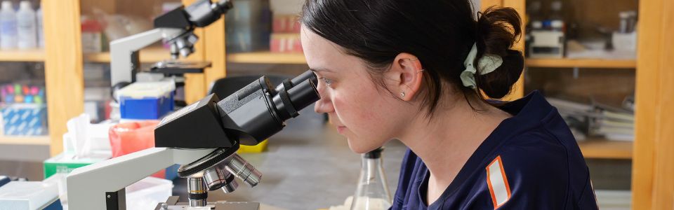 student using microscope