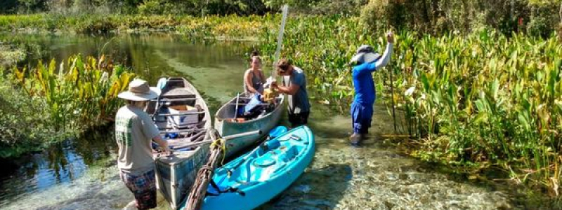 students working on the lake with boats and other equipment