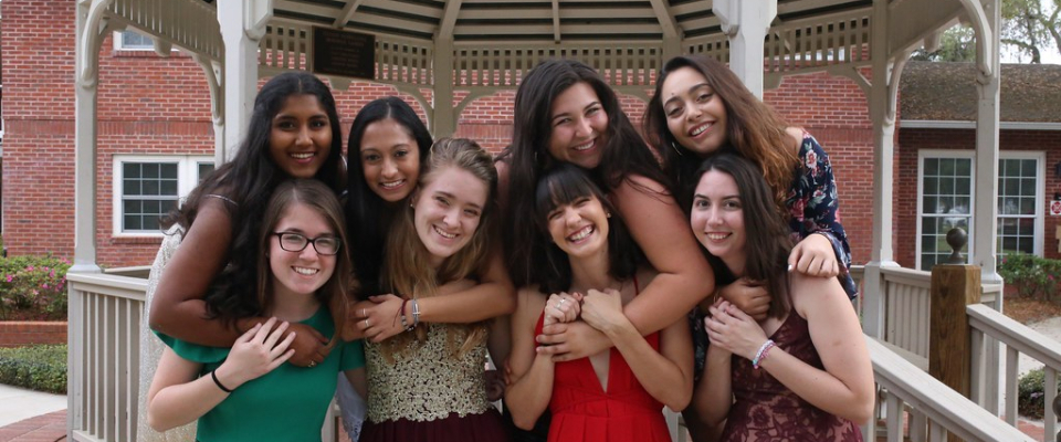 Group of students hugging at a gazebo