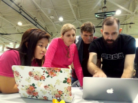 Faculty with students looking at a laptop