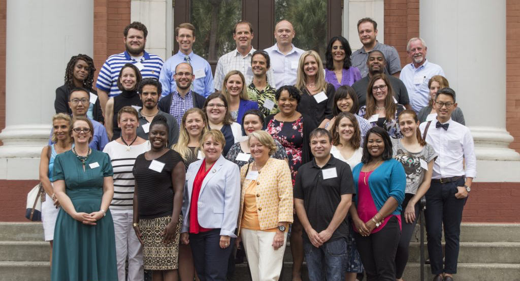 Assisting Faculty, posing for a picture in front of Sampson Hall