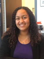 Aaryanna smiling in front of office door