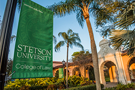 A green banner hangs in front of the Stetson College of Law