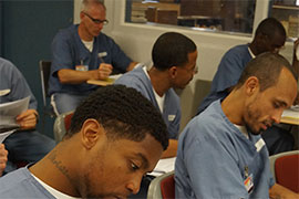 inmates work in a classroom on assignments