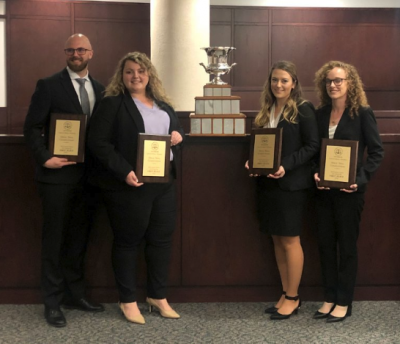 Four law students hold their winning plaques