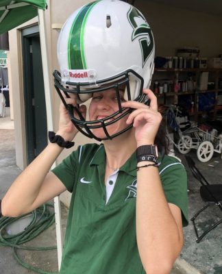 Hannah Churms puts on a Stetson football helmet.