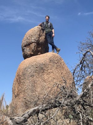 Ethan Fagan stands atop a big boulder,