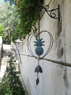 A bell hangs from the garden wall
