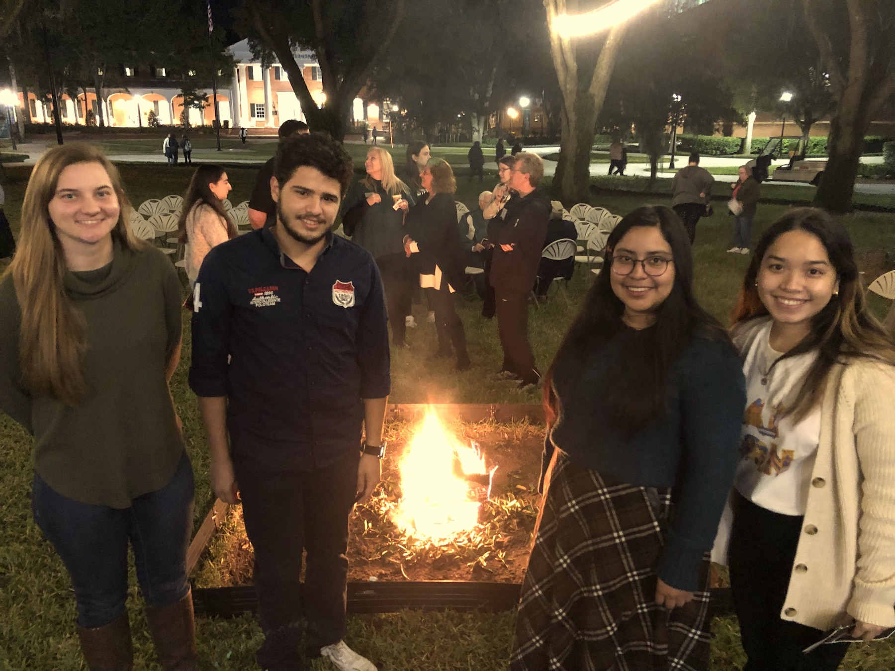 The student speakers pose in front of the roaring Yule Log fire